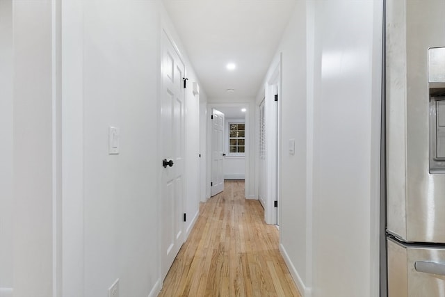 corridor with light hardwood / wood-style floors