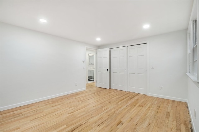 unfurnished bedroom with a closet and light hardwood / wood-style floors