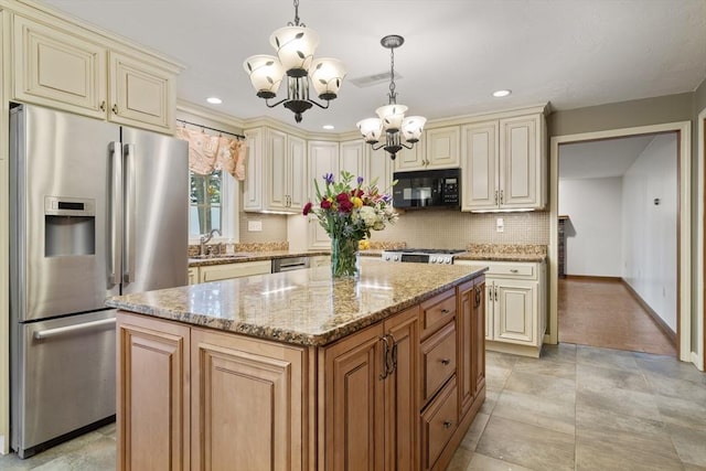 100 Avery Heights Dr, Holden, MA 01520 - kitchen with appliances with stainless steel finishes, cream cabinets, a chandelier, light stone countertops, and tasteful backsplash