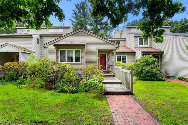 view of front facade featuring a front yard and a wooden deck