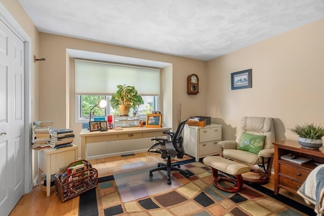 home office featuring light wood-type flooring and visible vents