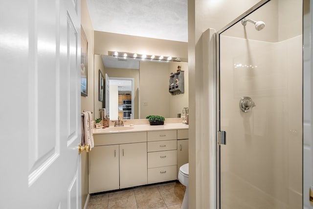 bathroom with tile patterned floors, vanity, toilet, a shower with shower door, and a textured ceiling