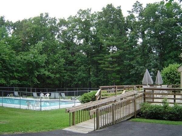 community pool featuring fence and a lawn