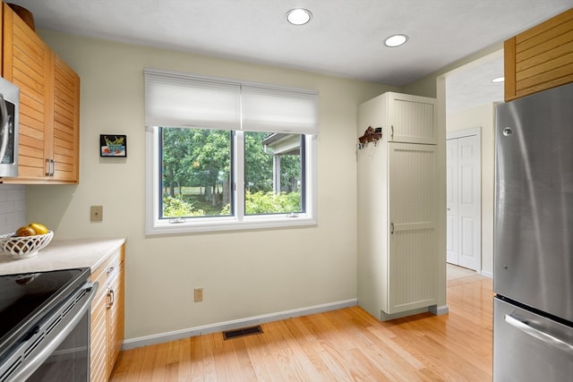 kitchen with light hardwood / wood-style flooring and stainless steel appliances