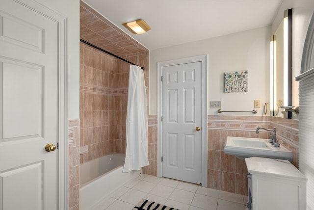 bathroom with tile walls, tile patterned flooring, sink, and shower / bath combo with shower curtain