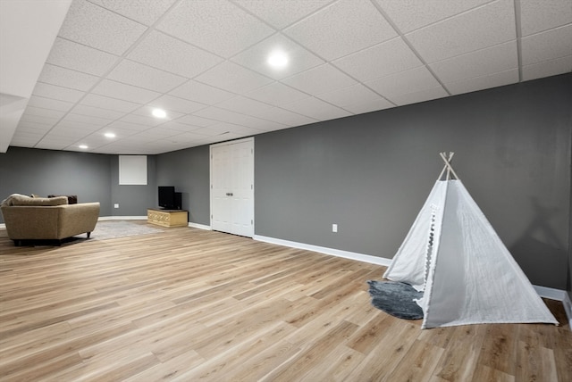 recreation room with a drop ceiling and light hardwood / wood-style floors