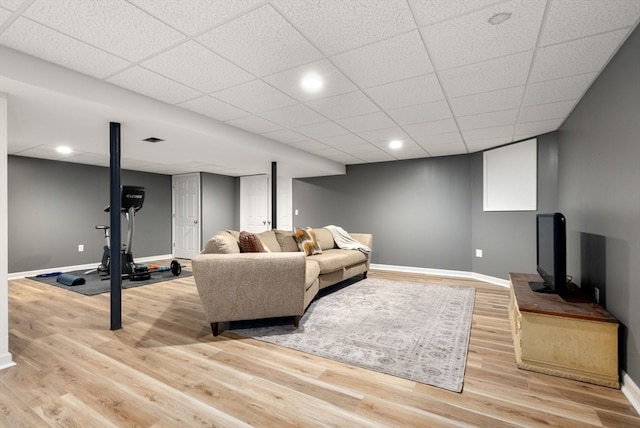 living room with a drop ceiling and light hardwood / wood-style floors