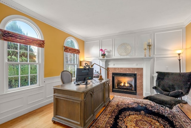 office with ornamental molding, a fireplace, and light hardwood / wood-style flooring