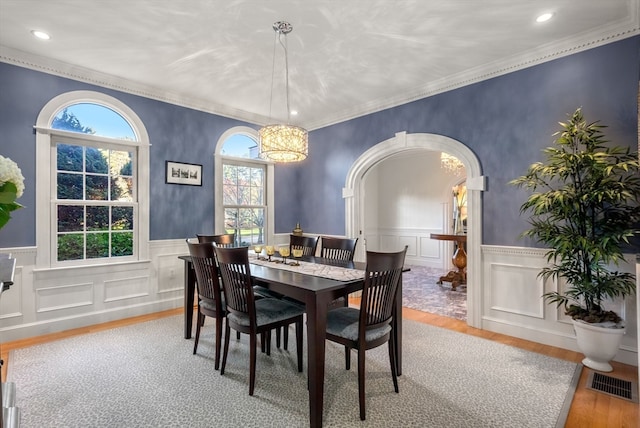 dining room featuring a wealth of natural light, hardwood / wood-style flooring, and crown molding