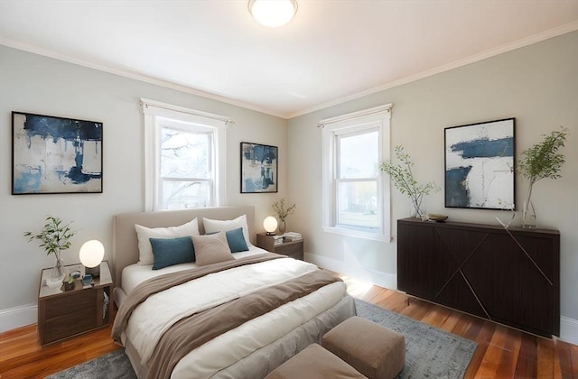 bedroom featuring baseboards, multiple windows, and wood finished floors