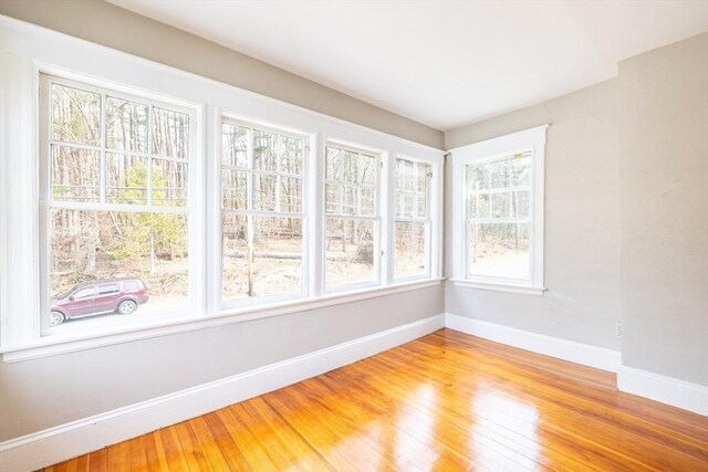 unfurnished room with baseboards and light wood-type flooring