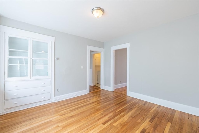 unfurnished bedroom featuring baseboards and light wood-type flooring