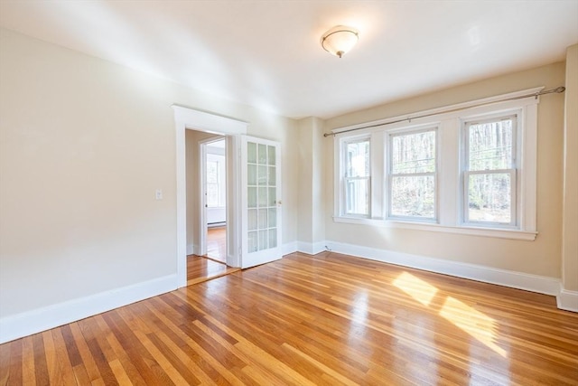 unfurnished room with baseboards and light wood finished floors