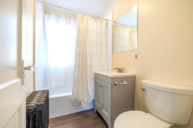 bathroom featuring vanity, radiator, wood finished floors, and toilet