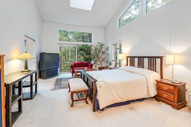 bedroom with high vaulted ceiling, a skylight, and multiple windows