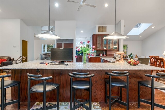 kitchen featuring a large island, a kitchen breakfast bar, decorative light fixtures, and a skylight