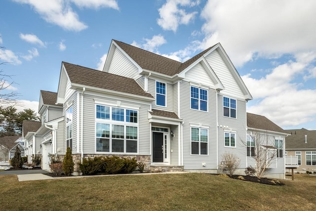 view of front of house featuring driveway, stone siding, a residential view, roof with shingles, and a front yard