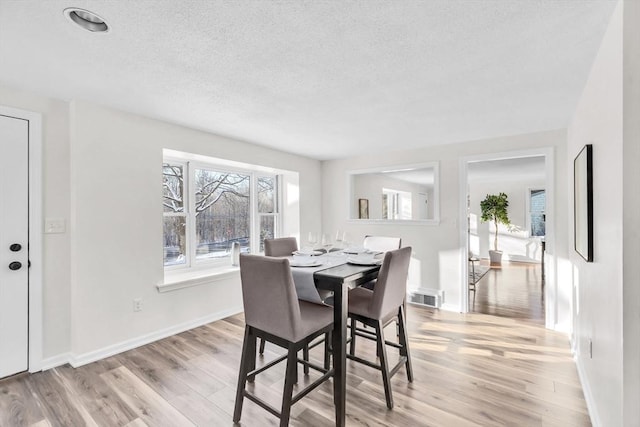 dining space with light hardwood / wood-style flooring