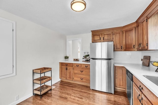 kitchen with sink, light hardwood / wood-style floors, and stainless steel appliances