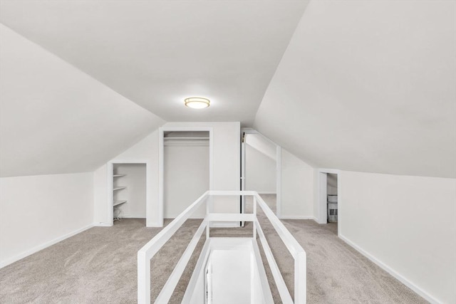 bonus room featuring vaulted ceiling and light colored carpet