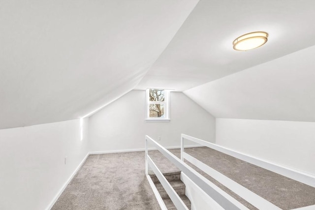 walk in closet with carpet and lofted ceiling