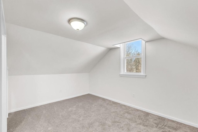 additional living space with light colored carpet and lofted ceiling