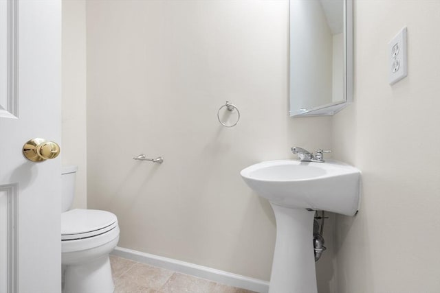 bathroom with tile patterned floors, baseboards, and toilet