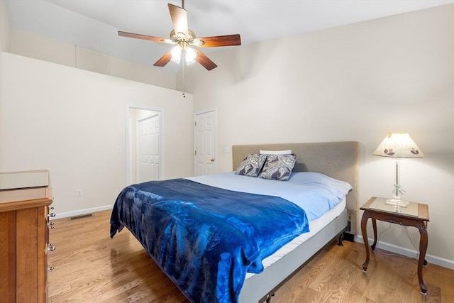 bedroom with light wood-style flooring, baseboards, visible vents, and ceiling fan