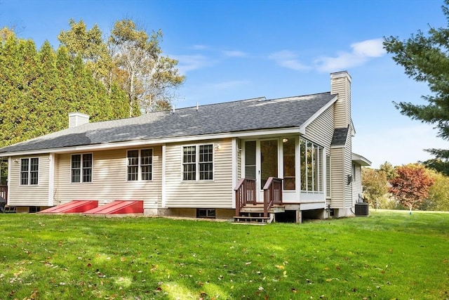 rear view of property with cooling unit, a yard, roof with shingles, and a chimney