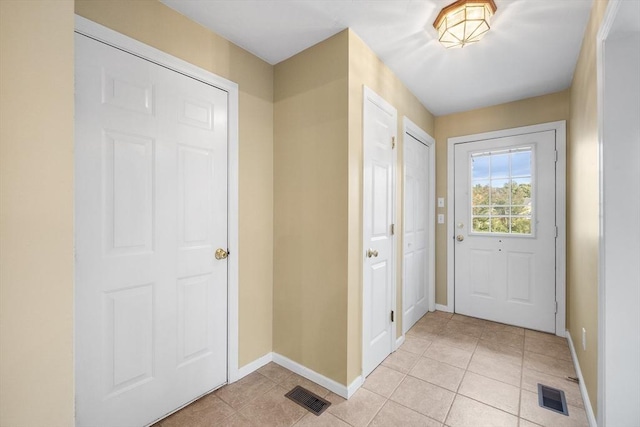 entryway with light tile patterned flooring, baseboards, and visible vents