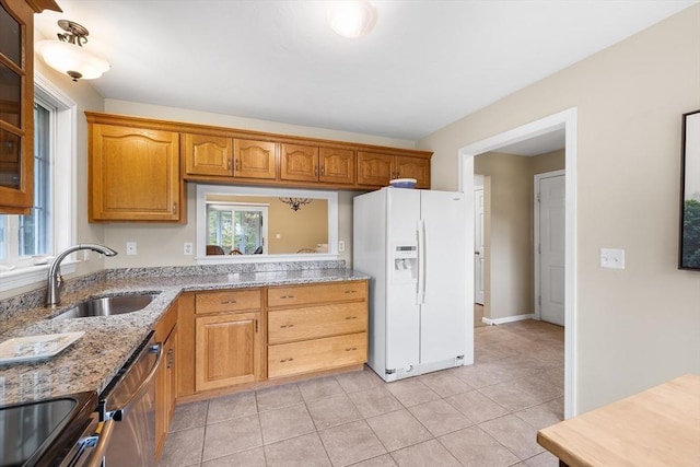 kitchen featuring a sink, plenty of natural light, stainless steel dishwasher, and white fridge with ice dispenser