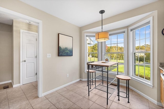 dining room with light tile patterned floors, baseboards, and a wealth of natural light