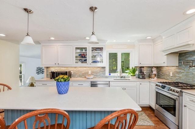 290 Cotuit Bay Dr, Barnstable, MA 02635 - kitchen with appliances with stainless steel finishes, a sink, a breakfast bar area, light countertops, and recessed lighting