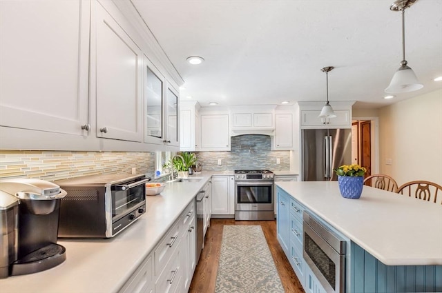 290 Cotuit Bay Dr, Barnstable, MA 02635 - kitchen with stainless steel appliances, white cabinets, dark wood-style floors, light countertops, and backsplash