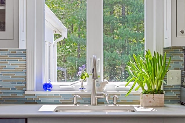 290 Cotuit Bay Dr, Barnstable, MA 02635 - kitchen view of decorative backsplash, a sink, and white cabinetry
