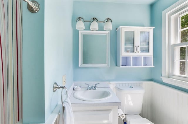 290 Cotuit Bay Dr, Barnstable, MA 02635 - bathroom with toilet, vanity, and a wainscoted wall