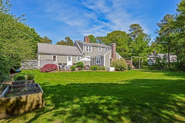 290 Cotuit Bay Dr, Barnstable, MA 02635 - rear view of house featuring a garden and a chimney