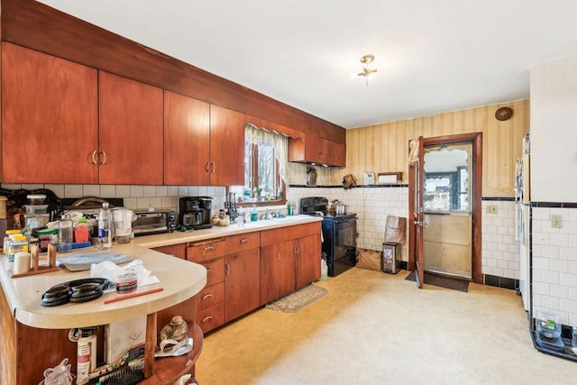 kitchen with a toaster, tile walls, light countertops, black electric range oven, and a sink