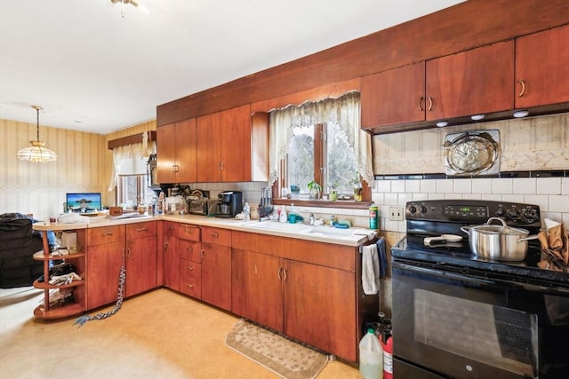 kitchen with a wealth of natural light, black electric range, light countertops, and a sink