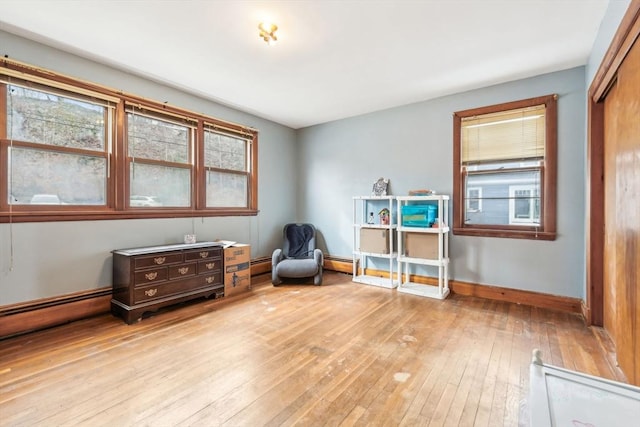 miscellaneous room with light wood finished floors, baseboards, and a baseboard heating unit