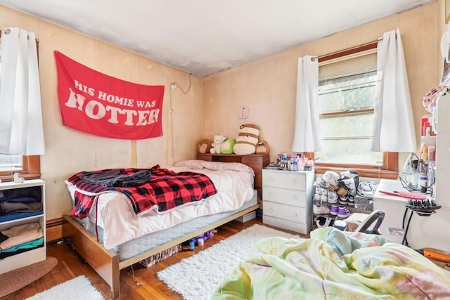 bedroom with baseboard heating and wood finished floors