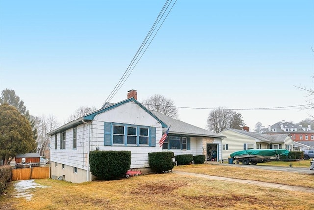 bungalow featuring a chimney, fence, and a front lawn