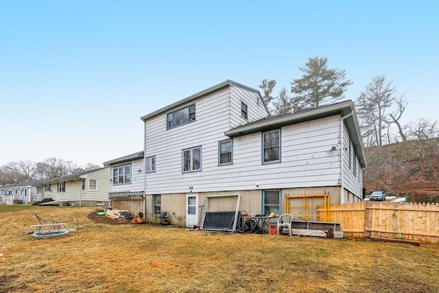 back of house featuring a yard and fence