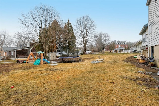 view of yard with a trampoline and a playground