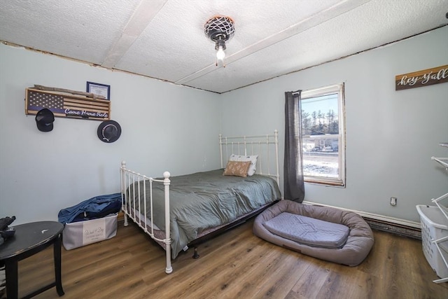 bedroom featuring dark hardwood / wood-style flooring and a textured ceiling