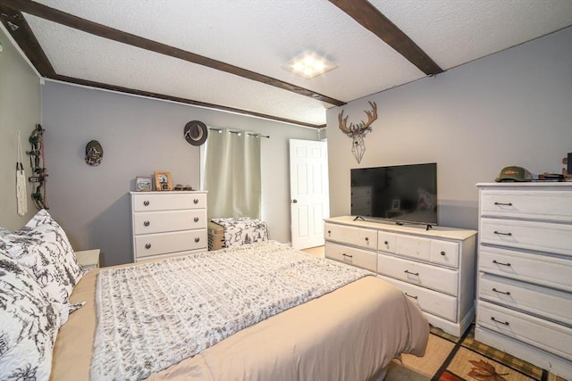 bedroom with beam ceiling and a textured ceiling