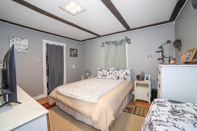 bedroom featuring a textured ceiling and light hardwood / wood-style flooring