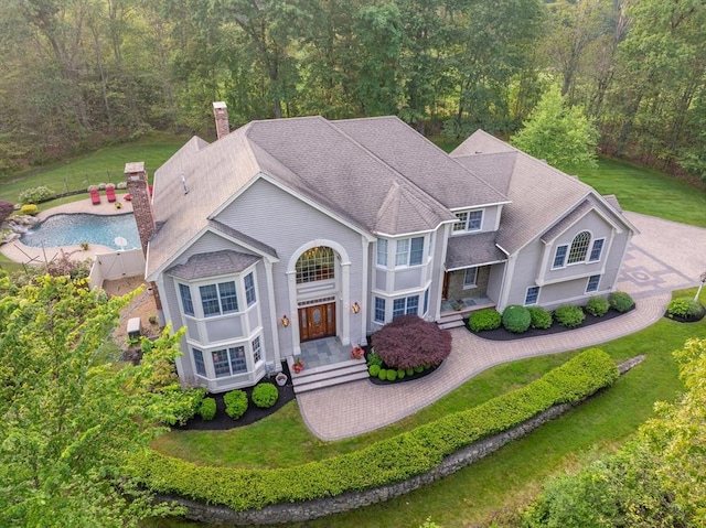 29 Hoveys Pond Dr, Boxford, MA 01921 - view of front of house featuring a chimney, a wooded view, and a front lawn