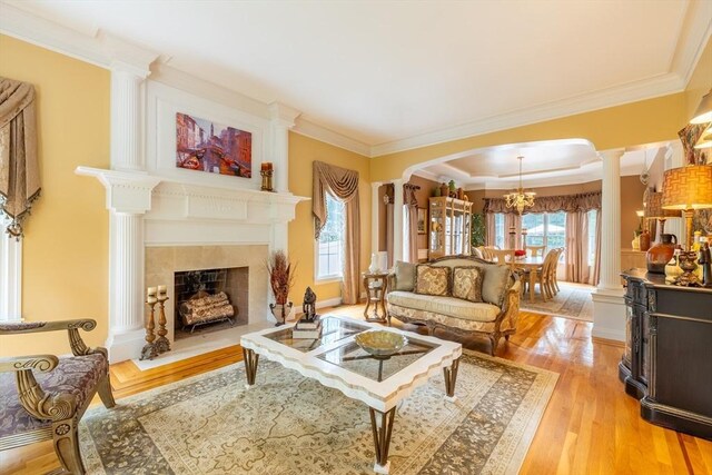 29 Hoveys Pond Dr, Boxford, MA 01921 - living room featuring a tile fireplace, light wood finished floors, arched walkways, ornamental molding, and a chandelier