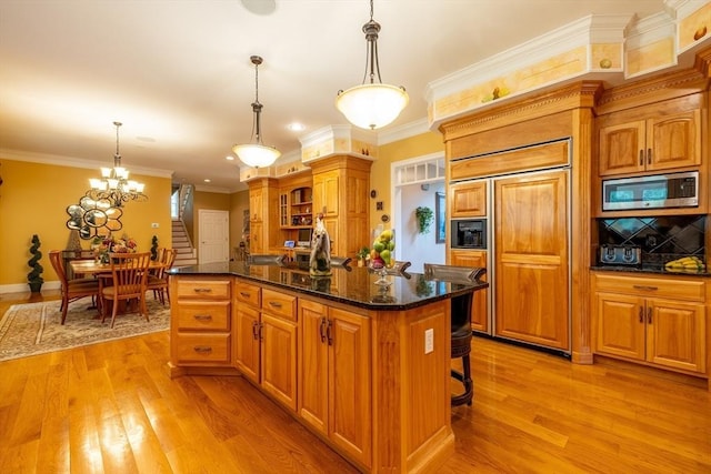 29 Hoveys Pond Dr, Boxford, MA 01921 - kitchen featuring built in appliances, light wood-style flooring, a center island, a breakfast bar, and crown molding